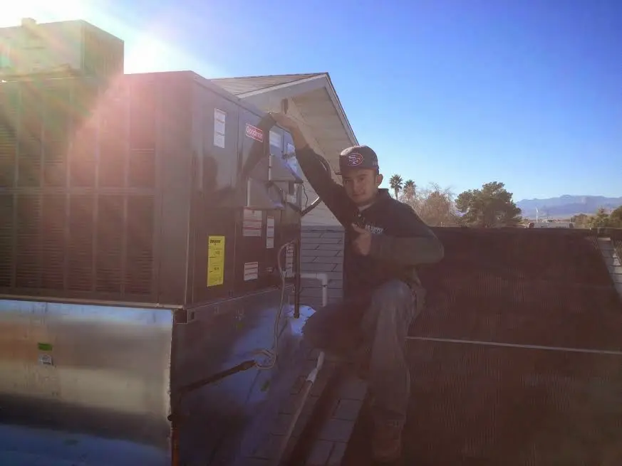 HVAC technician performing Air Duct Cleaning on a rooftop unit in Lake Butler